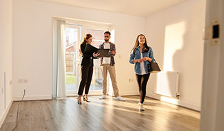 A couple tours an unfurnished apartment with a leasing agent.