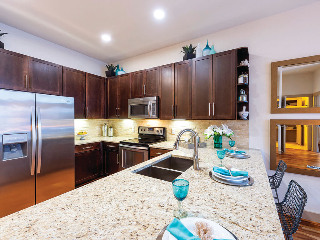 A modern kitchen with a large marble counter at the Block 334 Apartments in Houston, Texas.