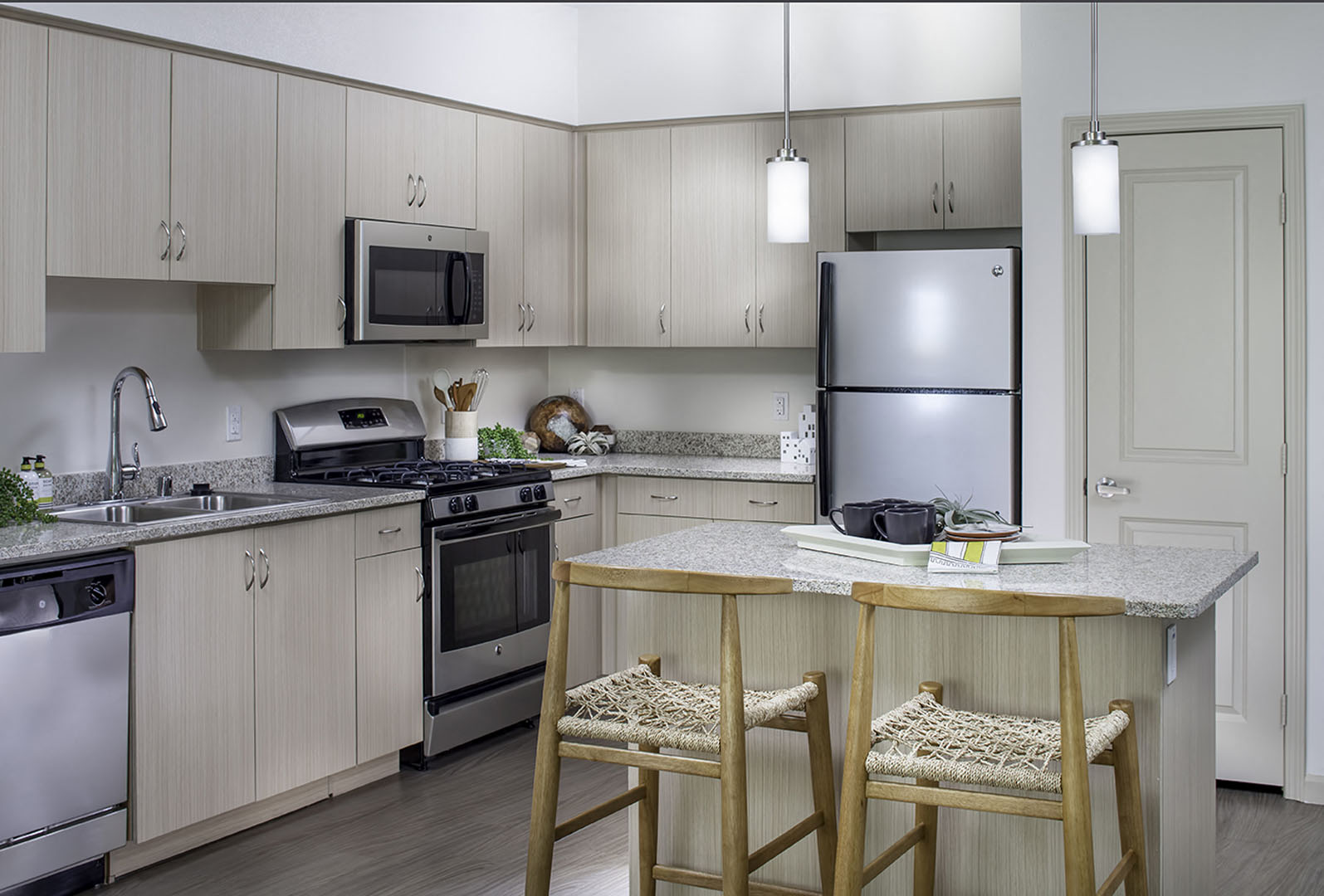 A modern kitchen with a kitchen island at the Pulse Millennia Apartments in Chula Vista, California.