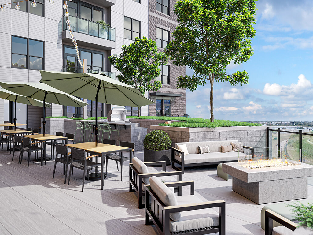 Terrace at East Bend Apartments offers plentiful outdoor seating. Plush couches face a concrete fire table and offer views of Houston.