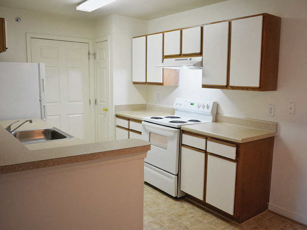 A kitchen with white cabinets at the Whispering Oaks Apartment Homes in Portsmouth, Virginia.