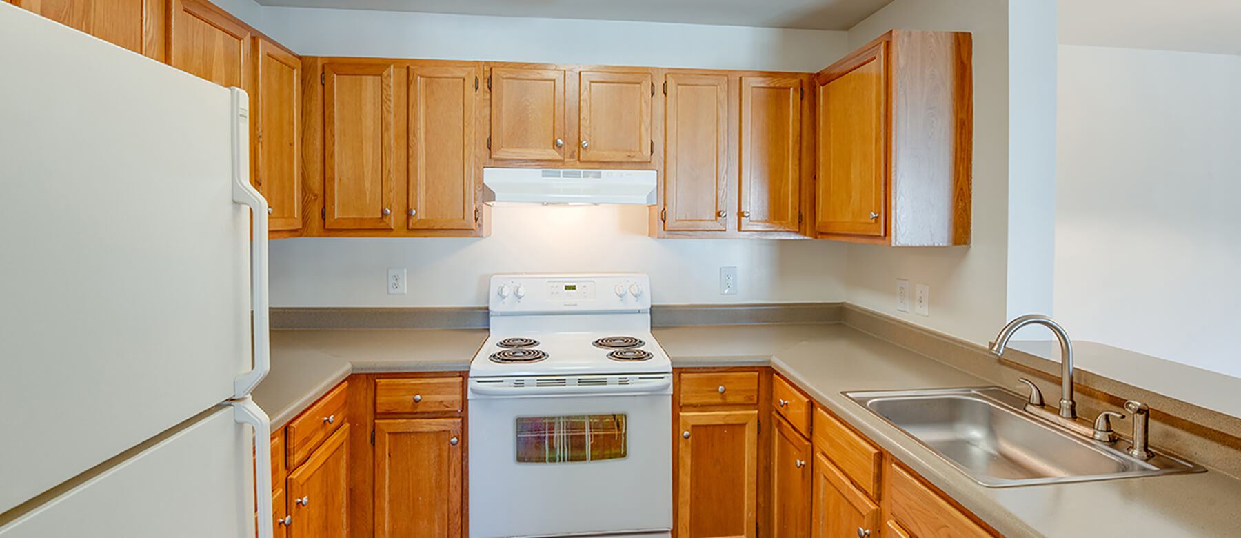A kitchen with white appliances at the Riverwoods, Riverwoods at Towne Square, and Riverwoods at Lake Ridge Apartments in Woodbridge, Virginia.