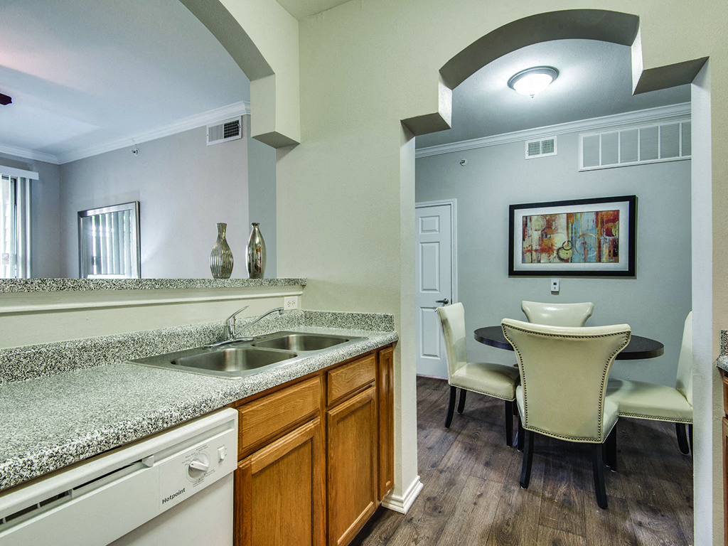 The kitchen leading into the dining room at the Kensley Apartment Homes in Irving, Texas.