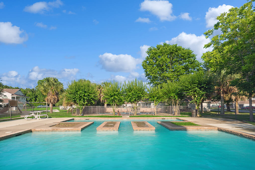 The large community pool and landscaping at the Dayton Park Apartments in Houston, Texas.