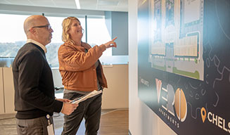 Two Fairfield associates examine a site map on the wall at the corporate office.