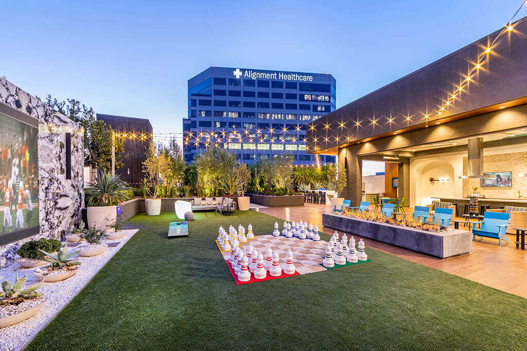 Rooftop lounge with lawn games and seating at the Aura Apartment Homes in Orange, California.