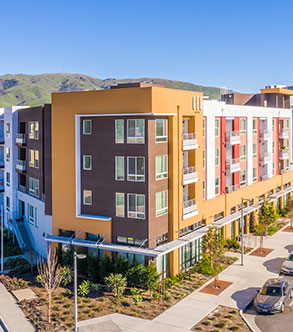 Bright building exterior of one of Fairfield's vibrant affordable housing communities, with the mountains in the background.
