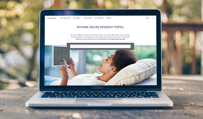 An open laptop showing MyHome Online Resident Portal site sits on an outdoor table with a blurred background.