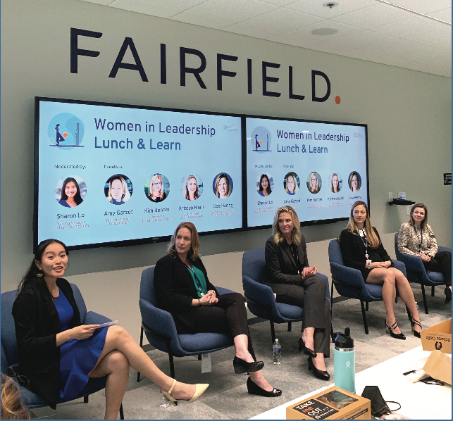 Panel of 5 women in front of presentation screens at the Women in Leadership Lunch and Learn.
